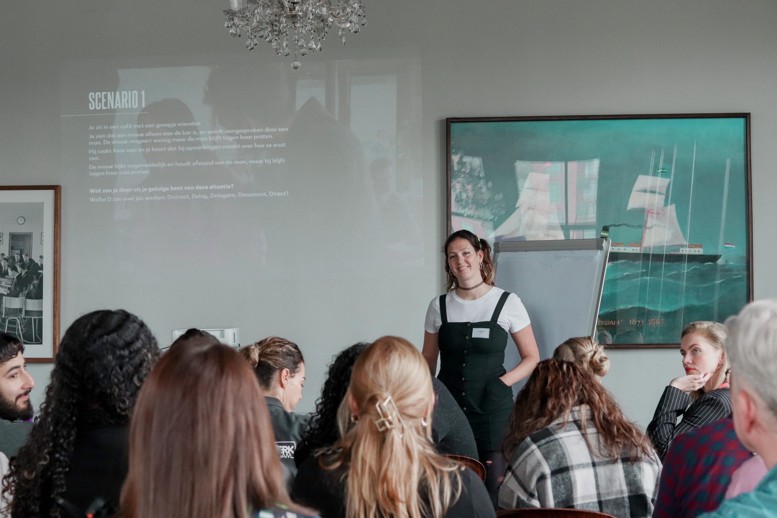 Myrthe van Gestel is aan het presenteren voor een groep jonge mensen.